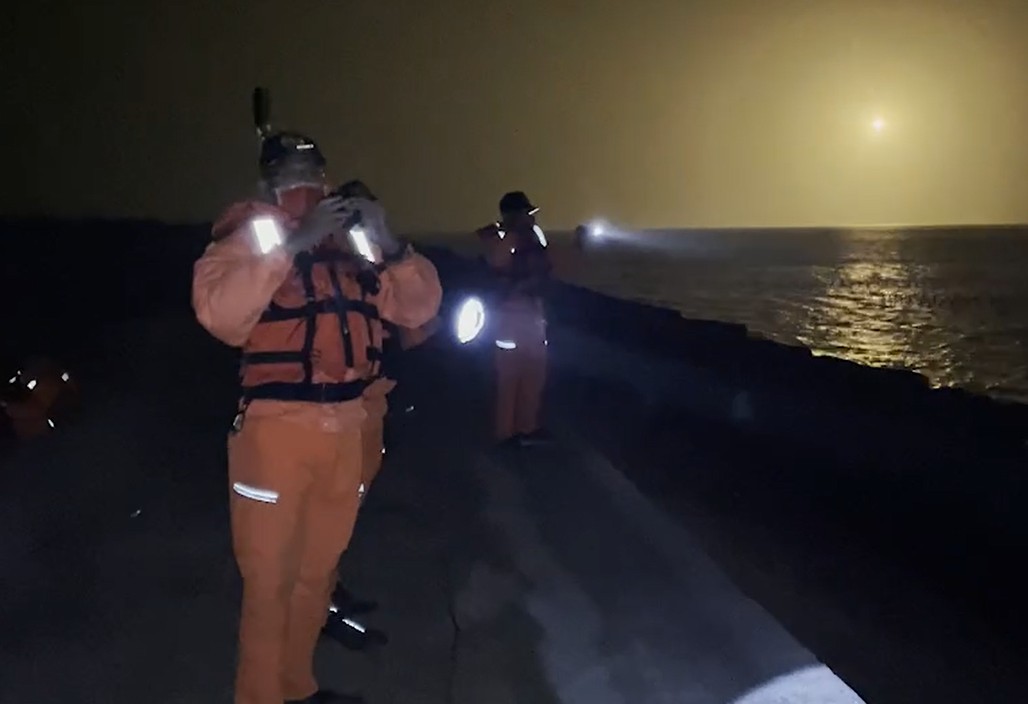 海巡在照明彈照射下，繼續夜間搜救。   圖：海巡署提供