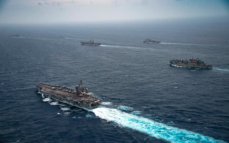 美軍「卡爾文森號(CVN-70)」航母(圖左下)和「艾塞克斯號(LHD-2)」兩棲攻擊艦(圖上方5艦居中)作戰群本月14日在南海展開聯合遠征打擊部隊行動。   圖：翻攝 USS Carl Vinson推特