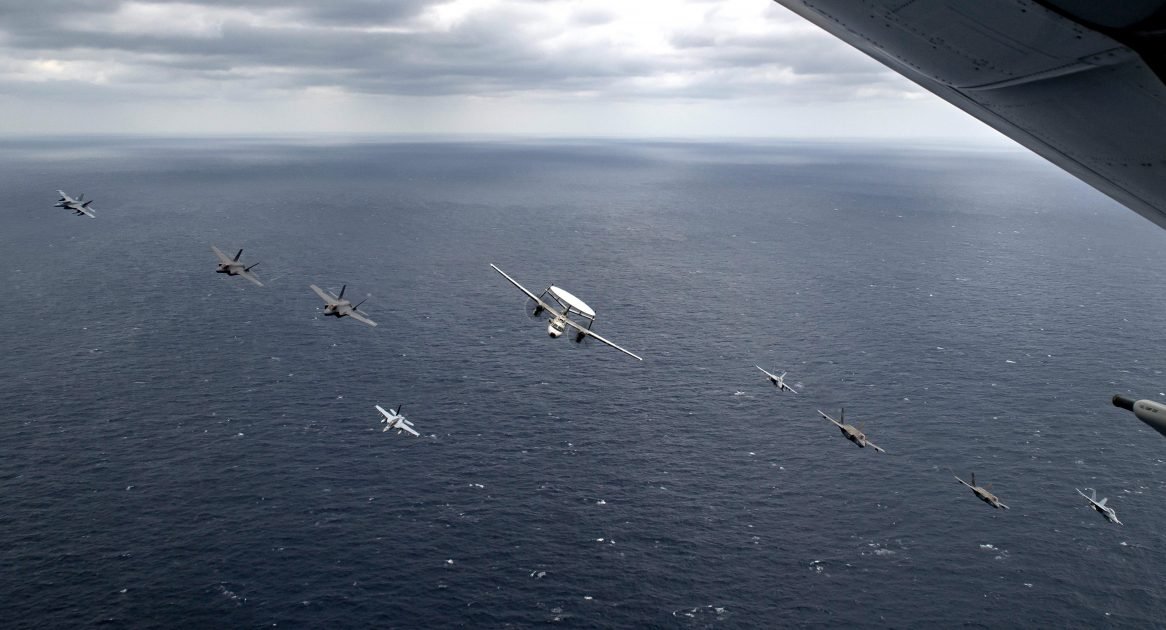 美軍航母、兩棲突擊艦22日菲律賓海軍演，艦載機編隊通過艦群。   圖：翻攝US Navy