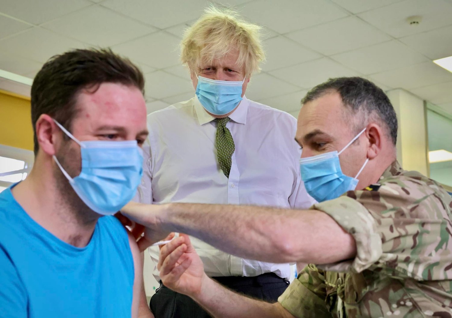英國首相強生（中）陸續取消防疫規定，改為強力宣導接種疫苗與普篩防疫。   圖：翻攝自強生臉書