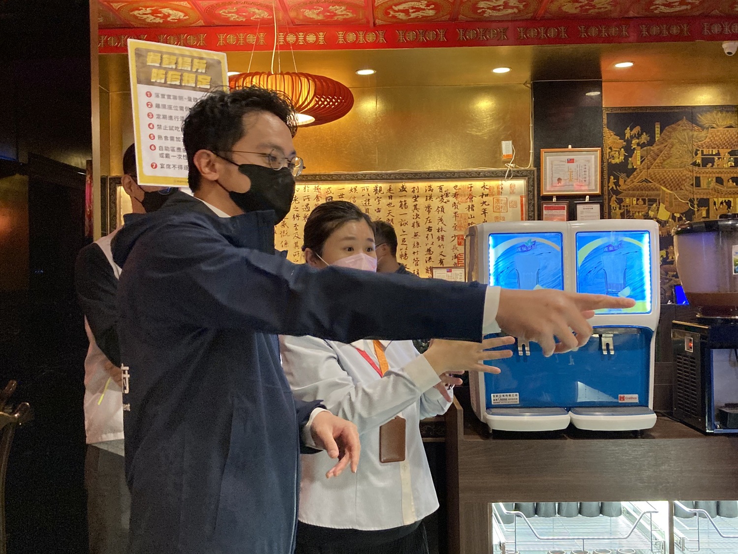 廖泰翔(左)稽查店家並宣導最新防疫規定。   圖：高雄市經發局提供