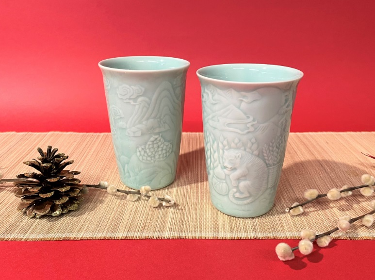 安達窯推出的「猛虎青瓷對杯」，杯身跋山取麥穗的猛虎，祝福順利闖過瞬息萬變的新年。   圖：鶯歌陶瓷博物館提供