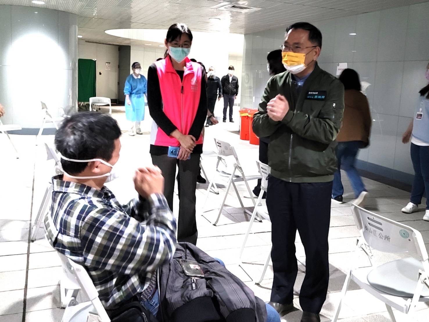 台北市副市長蔡炳坤視察捷運松山站疫苗接種站，向民眾拜年。   圖：台北市政府 / 提供