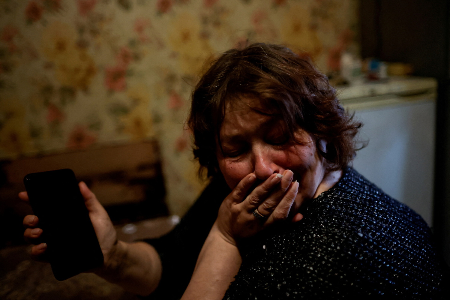 烏克蘭人道狀況嚴峻，烏國1 名婦女與戰場前線丈夫通話後哭泣。   圖：達志影像／路透社