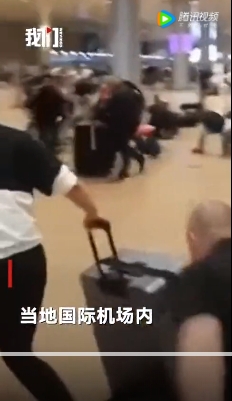 以色列機場安保人員發出警報後，現場許多旅客嚇得驚惶奔逃。   圖：翻攝自騰訊網