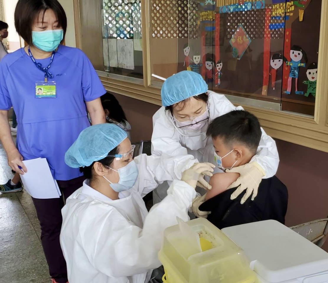 小學生在醫護安慰下完成接種。   圖：高雄市教育局提供