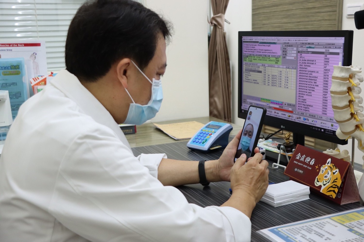 台灣健保與對抗COVID-19疫情之經驗獲得國際肯定，健保署與國際知名出版社Springer Nature合作合作出版談論台灣健保、對抗COVID-19疫情之經驗等英文專書「Digital Health Care in Taiwan- Innovations of National Health Insurance」(台灣數位健康照護)，電子書已於111年8月15日線上發行。(圖為醫生視訊看診。)   圖：高雄市衛生局提供