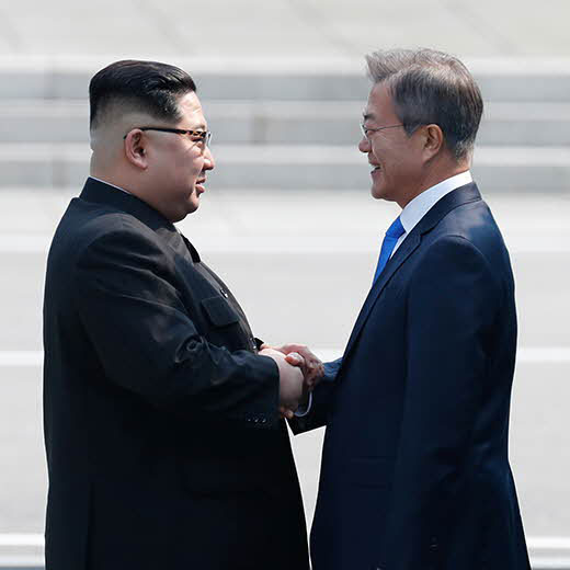 北韓領導人金正恩（左）與前南韓總統文在寅於南北韓共同警備區域握手。 圖：翻攝自維基百科