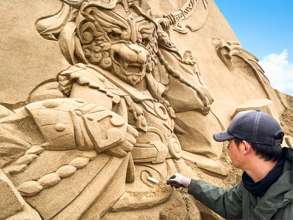 沙雕師正在雕刻《魔吞十二宮》人物「金獅」。   圖：福容大飯店／提供  
