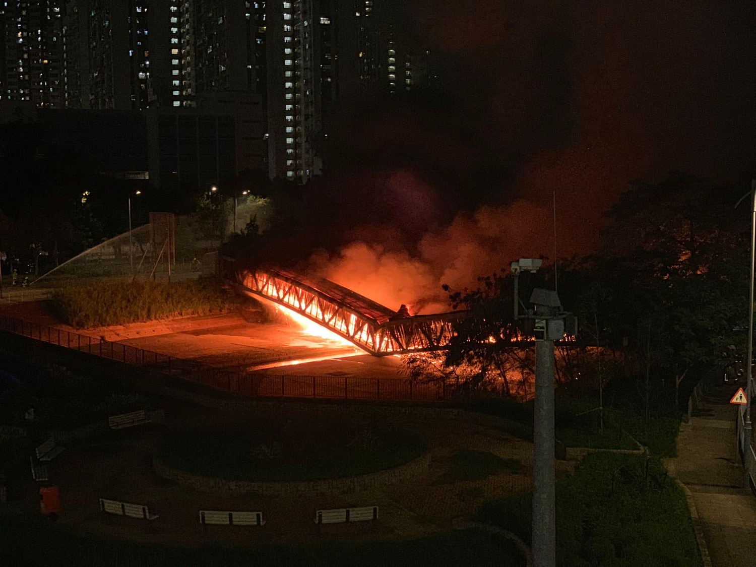 香港元朗區一座輸電橋傳出有連續爆炸聲響後大火，最新訊息是該輸電橋不耐大火高溫，於19時50分左右已經倒塌。   圖：翻攝香港突發事故報料區臉書粉專