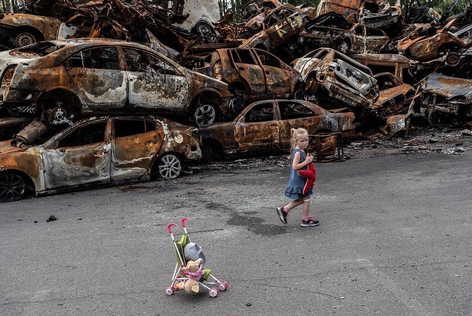 烏克蘭女童一人走在殘破的廢棄車前。   圖：擷取自烏克蘭總統澤連斯基臉書（資料照）