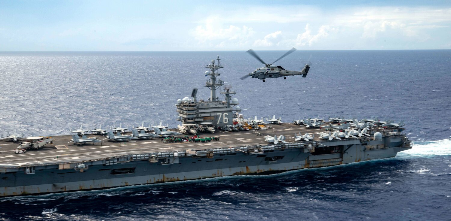 「雷根號(CVN-76)」航空母艦在菲律賓海操演，MH-60R「海鷹」直升機越過航艦。   圖：翻攝US Navy