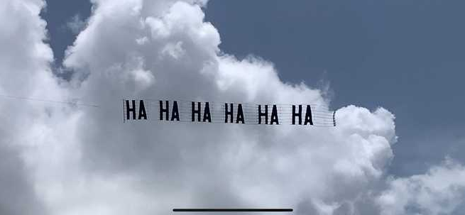 托馬斯．肯尼迪與朋友花費 1,800 美元，讓直升機拉著「HAHAHAHAHAHA」字樣的橫幅，於美國前總統川普位於佛州的「海湖莊園」上空盤旋。   圖：翻攝自環球網