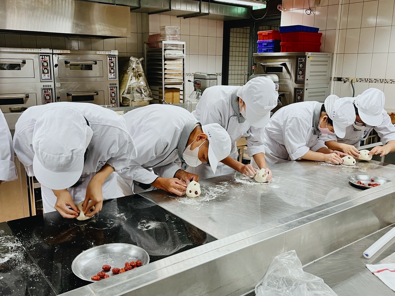 能仁家商餐飲科學生為饅頭鑲上紅棗。   圖：新北市文化局提供