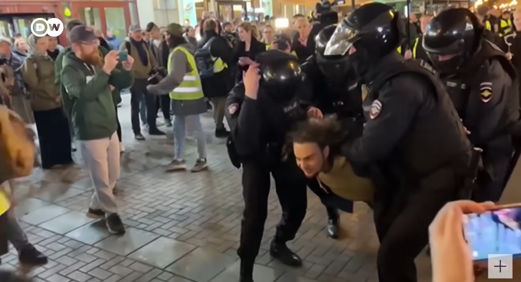俄羅斯徵召令引發民眾抗議，政府出動身穿鎮暴裝備的警方拘捕民眾。   圖: 擷取自 DW News YouTube