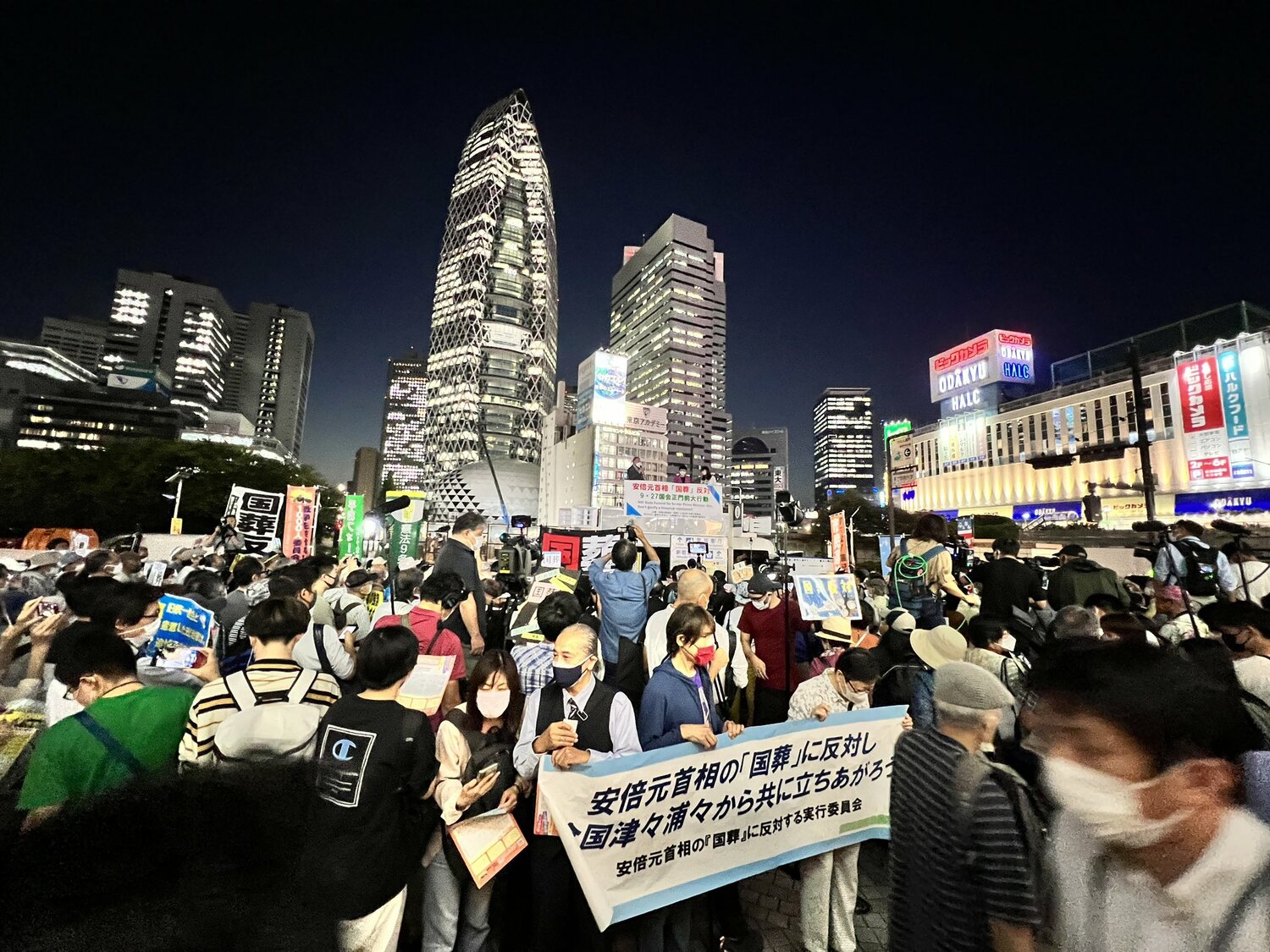 日本東京新宿站外民眾舉著「反對國葬」標語，抗議這次的安倍國葬。   圖：翻攝自推特