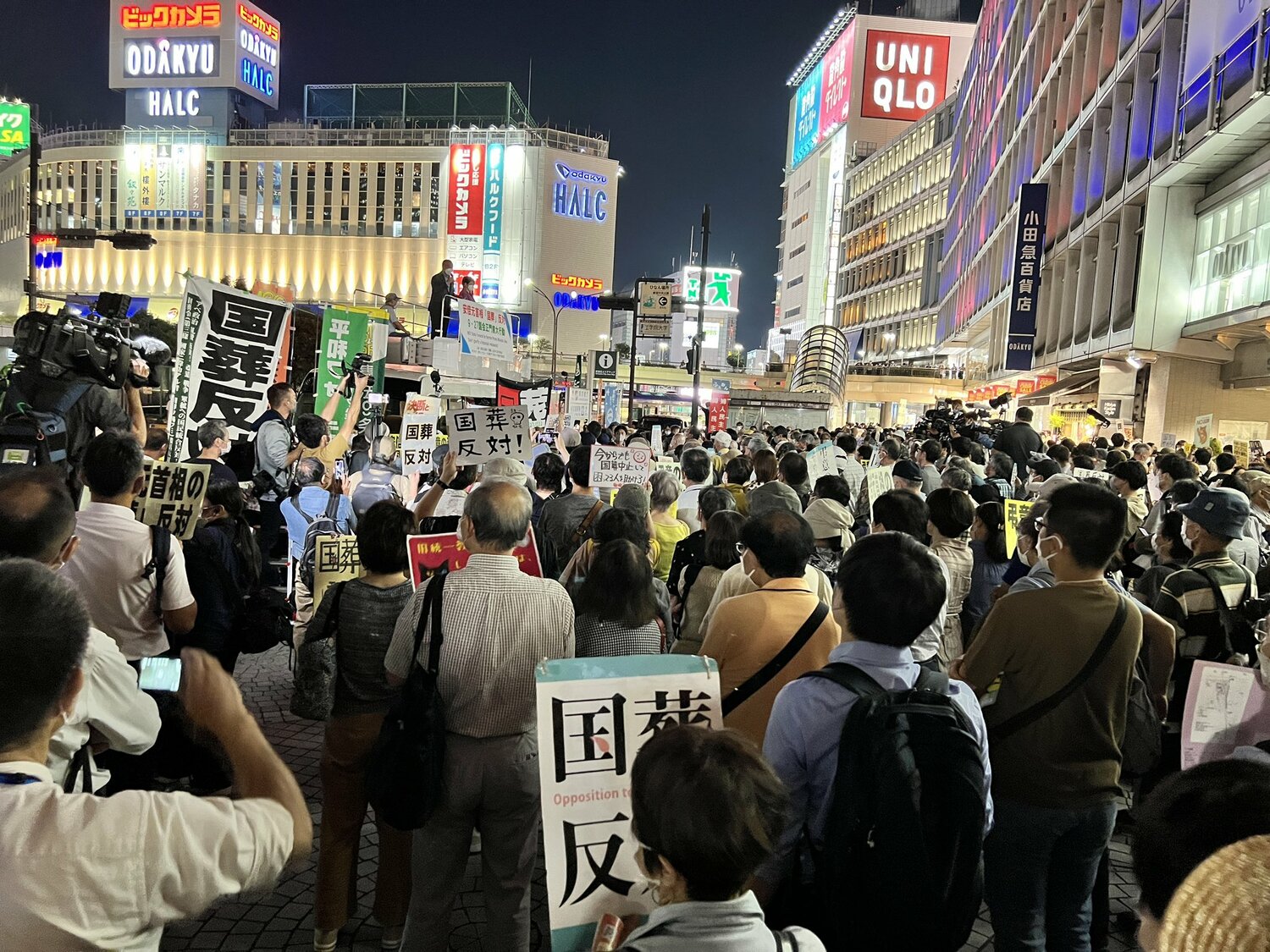 日本東京新宿站外民眾舉著「反對國葬」標語，抗議這次的安倍國葬。   圖：翻攝自推特