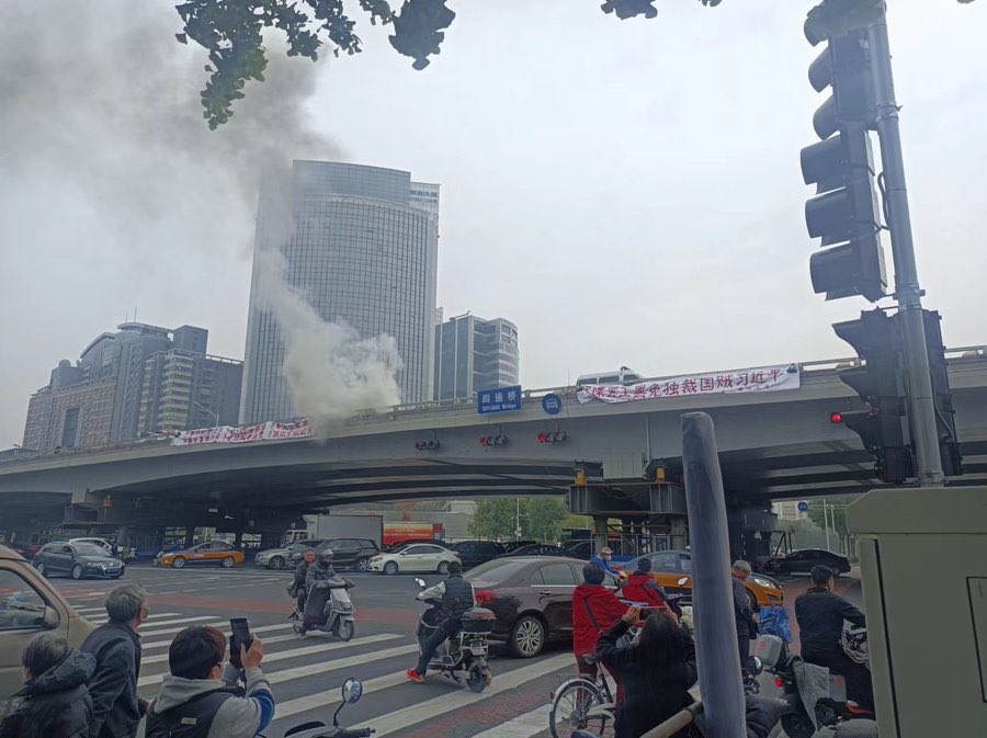 警方當眾在橋邊將橫幅燒毀，橋上冒起濃煙。   圖: 翻攝自Chen Jiangang推特 
