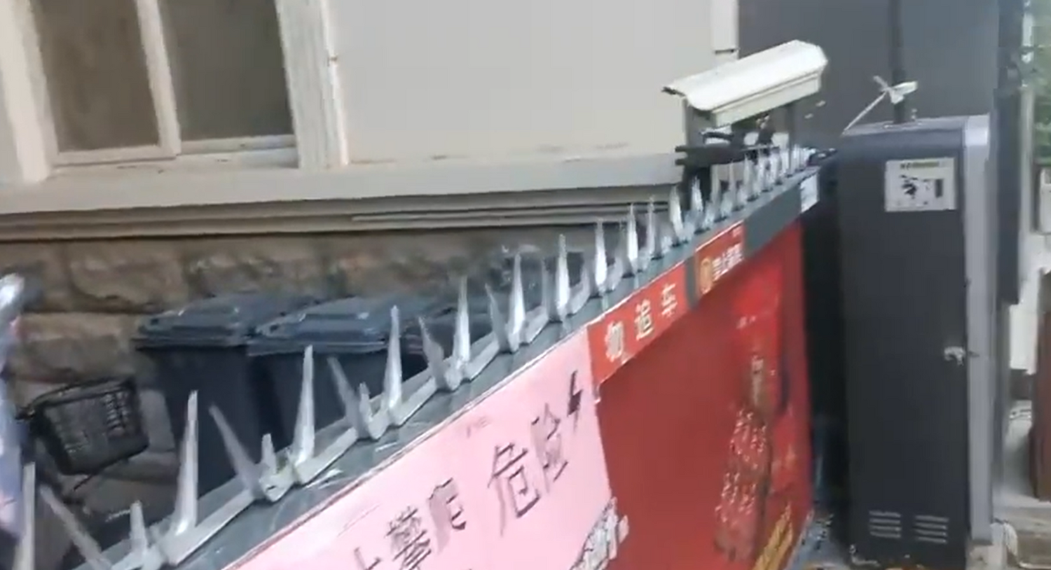 社區為了怕民眾外出，用鐵製成的尖刺，並將其栓在社區門上。   圖：翻攝自CCAVNewsShorts推特