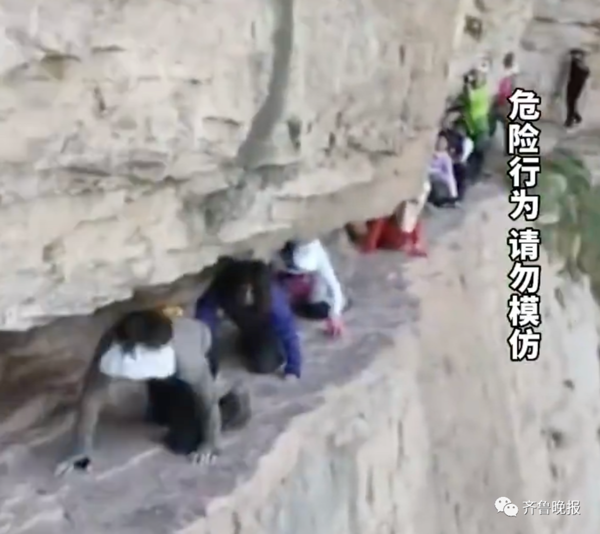 河南林州的遊客在無保護措施的情況下「狗爬式」爬過懸崖，引發嘩然。 圖：翻攝自新浪新聞