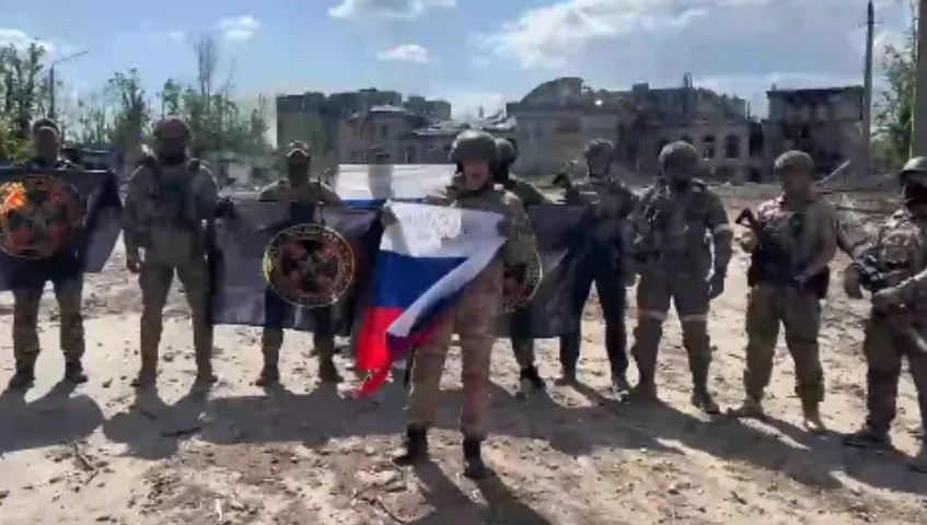 普里戈津拿著俄國國旗，與瓦格納軍團士兵合影。 圖：翻攝自推特