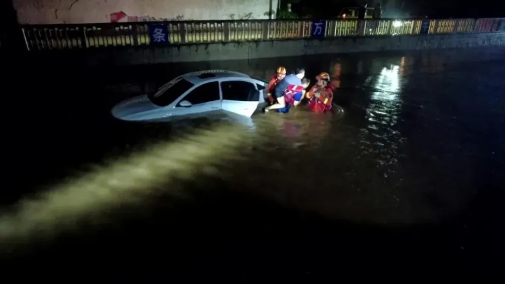 北京暴雨，民眾駕駛車輛受困於洪水之中，動彈不得，所幸救難人員即時救出。 圖：翻攝自騰訊網／《南方人物周刊》