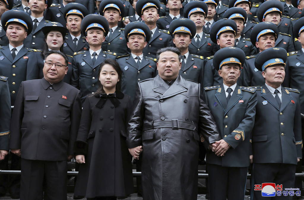  北韓領導人金正恩(中)攜女兒金主愛 (左2)參與軍事領域活動。圖為與國家航空宇宙技術總局的科學家和技術人員合影留念，慶祝軍事偵察衛星發射成功。 圖 : 朝中社(資料照片) 
