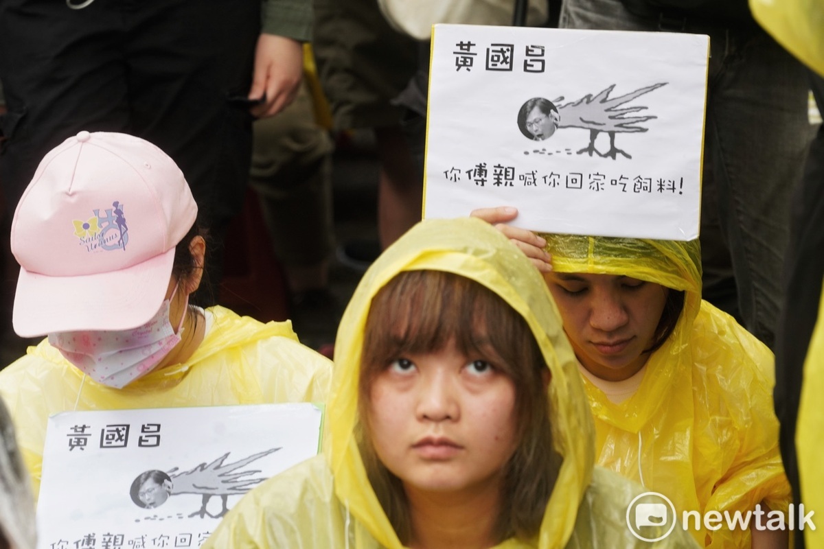  抗議民眾在立法院外的青島東路舉牌要協尋黃國昌。 圖：張良一/攝 
