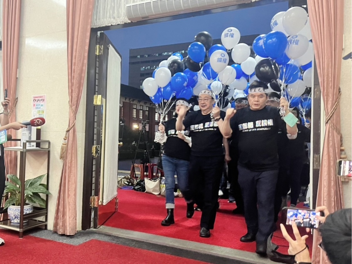  民進黨立院黨團由黨團三長帶頭，率領51席黨籍立委手舉藍白黑氣球進入議場。 圖：金大鈞/攝 