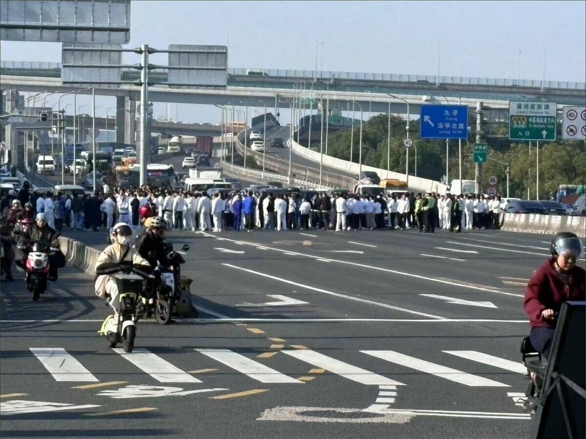 11月21日，上海七寶地區，國利公司資方長期拖欠工資而逼迫工人辭職。圖為工人們走上滬淞公路堵路維權。 圖：截自「 x 」@whyyoutouzhele 