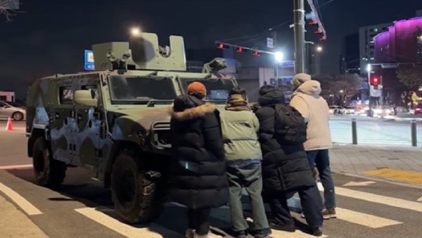  在南韓戒嚴風暴發生當晚，一位勇敢的抗議民眾以肉身阻擋南韓軍方裝甲車前往國會大廈，宛如中國的「坦克人」。而在南韓坦克人的鼓舞下，許多南韓抗議民眾也加入阻擋裝甲車前進的隊伍。 圖：翻攝自 @eggiscomming X 帳號 