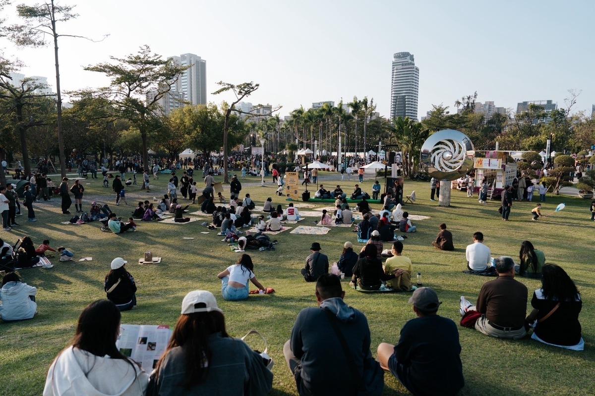 民眾席地而坐，享受初春午后的陽光。   圖：高雄市行政暨國際處/提供