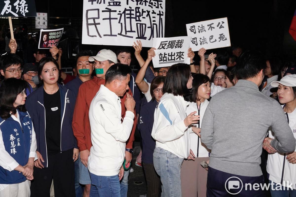 台北市長蔣萬安（右）講完話欲離去時，剛好遇警方第一次舉牌（左上）警告。   圖：張良一 / 攝