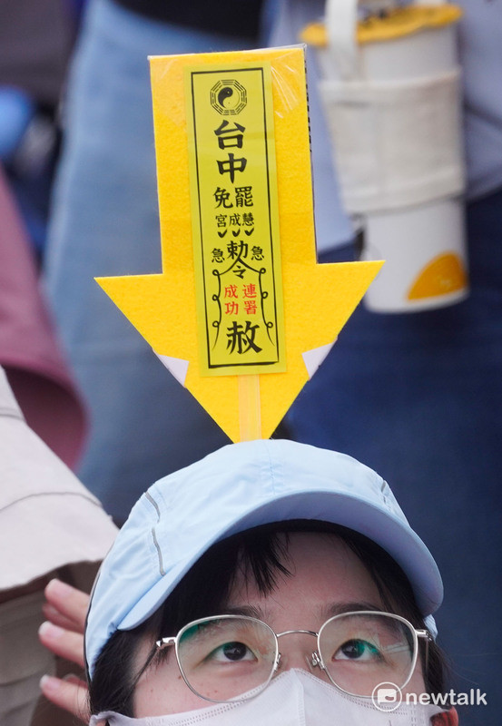 一位參加遊行的民眾將台中罷免慧成宮的符令插在自己的帽子上。   圖：張良一 /攝