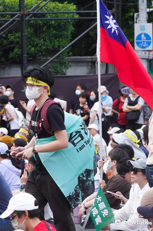 約五萬民群眾參與在凱達格蘭大道舉行的『419守護台灣 拒絕統戰』大遊行，人潮從凱達格蘭大道滿溢到仁愛路與信義路口，場面相當熱烈，一位民眾揹著台灣獨立旗從中華民國國旗旁邊經過，中華民國國旗與台灣獨立旗、台灣魂大旗並列出現在活動現場，不少民眾也拿著小幅國旗在人群中。一場大罷免遊行，讓中華民國派與台派走在一起，這是過往台派活動少見的景象。   圖：張良一 /攝