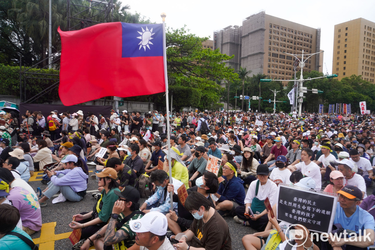 一面中華民國國旗在凱達格蘭大道的人群中飄揚。一場大罷免遊行，讓中華民國派與台派走在一起，這是過往台派活動少見的景象。   圖：張良一 /攝