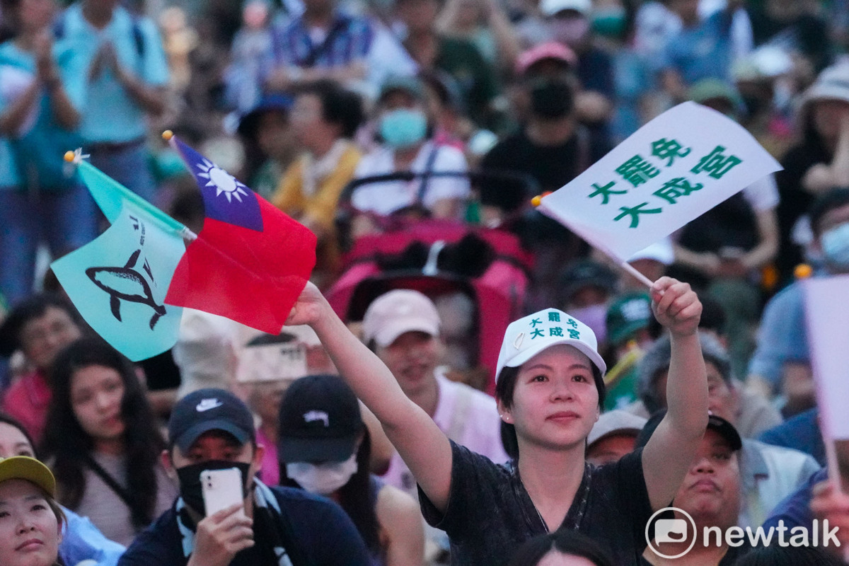 一位民眾高舉中華民國國旗、台灣獨立旗和大罷免大成宮三面旗幟參與大罷免遊行。   圖：張良一 /攝