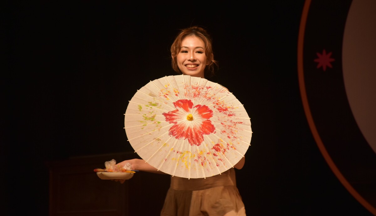 佳麗現場即興創作客家油傘畫。   圖：孫家銘攝