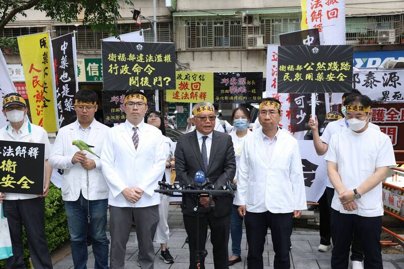 藥師公會帶來一隻「同胞鸚鵡」，象徵部長面對質疑時僅重複空泛說詞，缺乏實質回應。   圖：藥師公會／ 提供