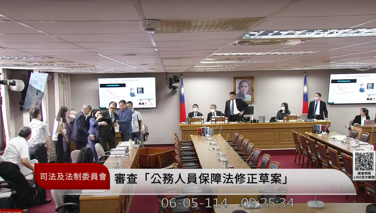 考試院秘書長劉建忻備詢時，因體力不支暈眩昏倒，遭眾人攙扶回到座位。   圖：翻攝自國會頻道