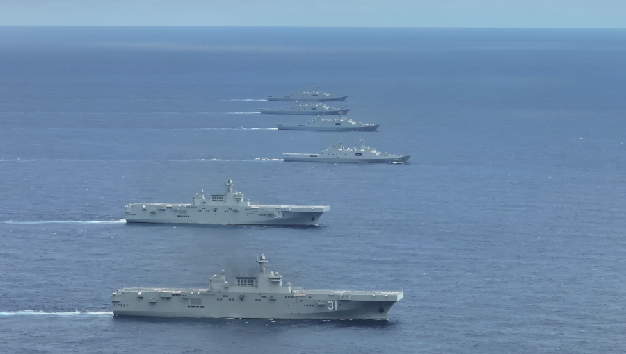  新華網報導，075型兩棲攻擊艦海南號（鏡頭前第1艘）、湖北號（第2艘）與至少 4 艘護衛艦在南海某海域進行實戰化訓練。(示意圖) 圖：翻攝新華網 