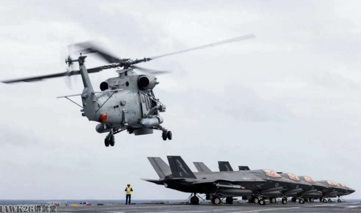  新西蘭海軍的 SH-2G 「超海妖」反潛直升機降落在英國皇家海軍「威爾士親王」號航母甲板上，與 F-35B 隱形戰機同場形成新舊裝備對比。 圖：翻攝自 hawk26講武堂 